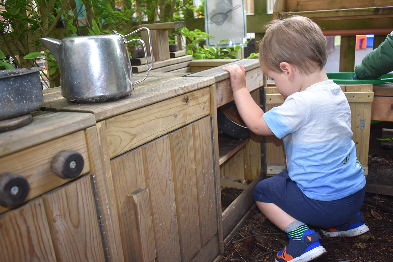 a child having fun in our mud kitchen