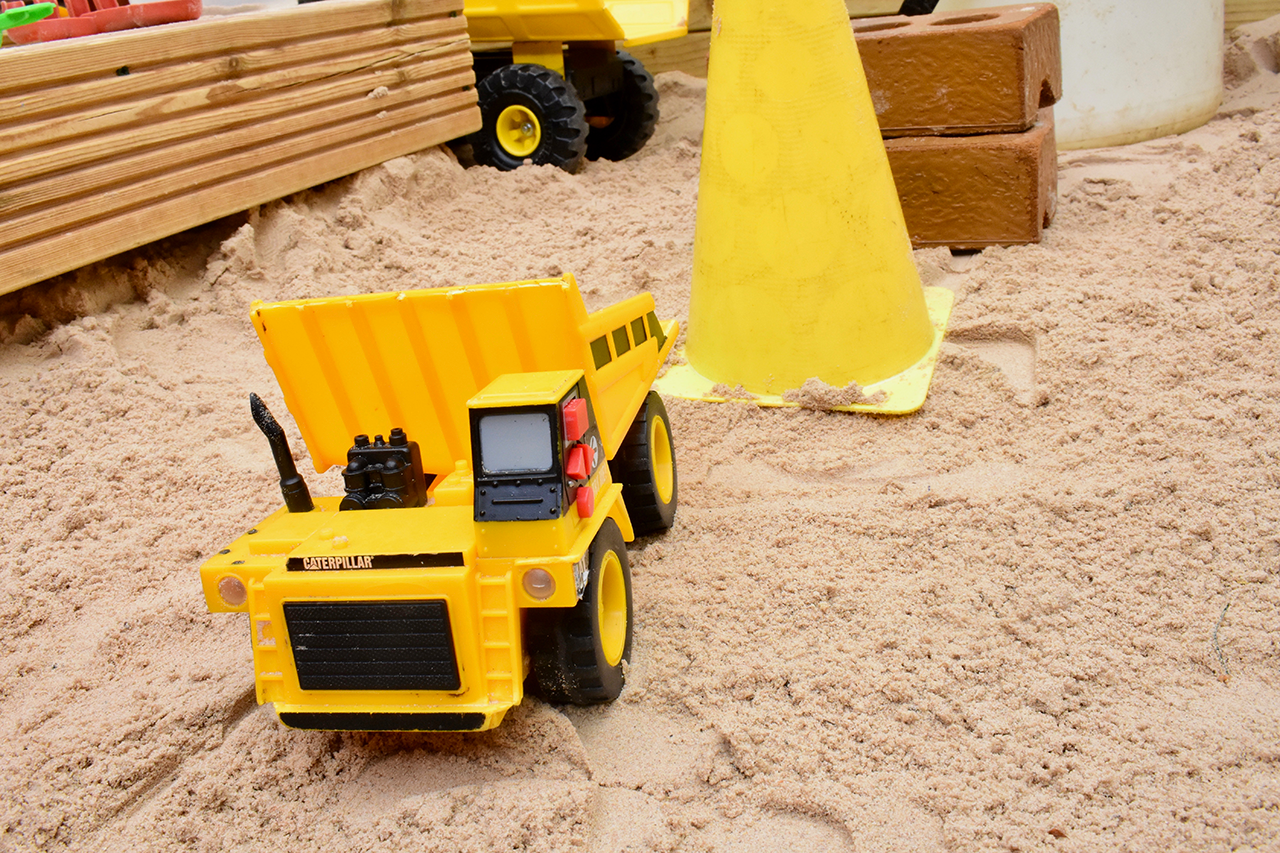 A toy digger in the sand
